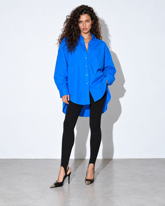 Koszula CALM Oversize Blue PATCHOULI – nowa modelka, legginsy CONFIDENT Black ze strzemionami pod stopą, czarne szpilki z metalowym noskiem, mocny flesz.